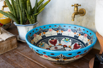 Vintage hand-washing basin on the counter top with brass faucet, painted ceramic bowl designed sink...