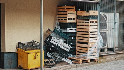 Empty Wooden and Plastic Food Crates Stacked Behind Grocery Store