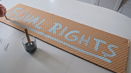 Human Rights Activist Preparing Banner for Political Demonstration Raid with Equal Rights Text...
