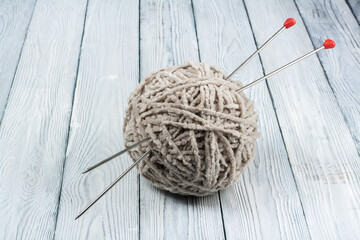 Ball of wool with spokes for handmade knitting on wooden table. Knitting wool and knitting needles.