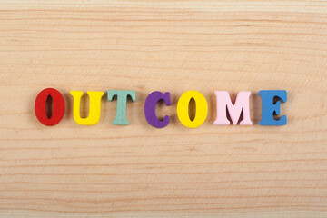 OUTCOME word on wooden background composed from colorful abc alphabet block wooden letters, copy space for ad text. Learning english concept.