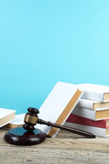 Law concept - Open law book with a wooden judges gavel on table in a courtroom or law enforcement...