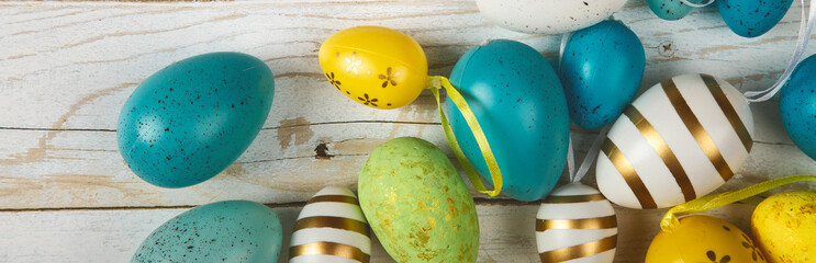 Happy easter banner. Colored Easter eggs on a wooden background