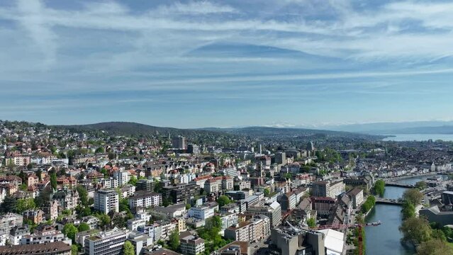 Round shot over Swiss City of Z&uuml;rich with Limmat River, Sihl River, Lake Z&uuml;rich and Swiss Alps on a sunny spring afternoon at Swiss City of Z&uuml;rich. Movie shot April 12th, 2024, Zurich, Switzerland.