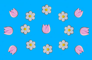 Gingerbread cookies in the shape of chamomile and tulip on the blue background. Top view. Copy space.