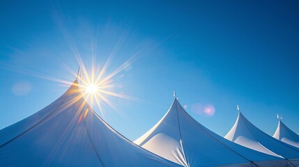 Peaks of tents against clear blue sky on a sunny day