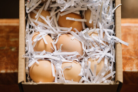 Eggs nestled in shredded paper in a box