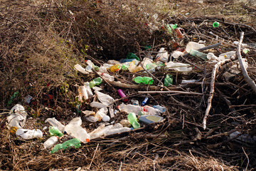 Plastic bottles and other garbage in the grass. Environmental pollution. Plastic pollution of the planet. Recycling