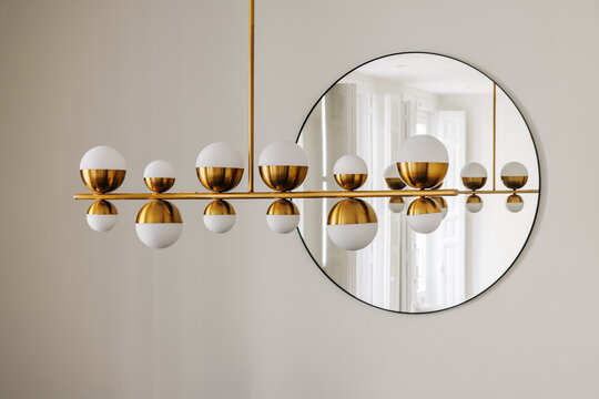 elegant ceiling lamp and circular mirror in a luxury apartment