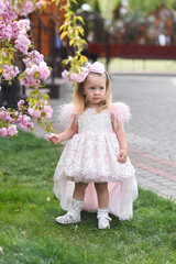 little girl in pink dress. little girl with pink flowers. little girl walking in the park