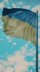 Ukraine flag in blue sky with clouds