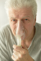 Close-up portrait of an elder man making inhalation
