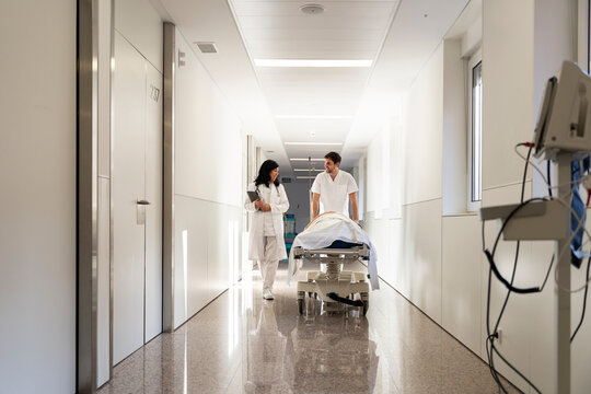 Medical staff wheeling patient in stretcher