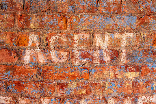 old colorful painted brick wall with word "agent"