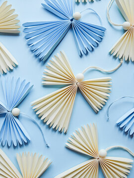 Handmade angels with head made of bead placed on blue background