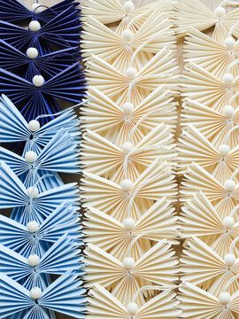 Angels made of paper in origami technique laying in rows on table