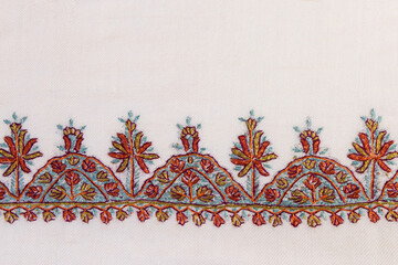Border with white traditional Kashmiri stitch embroidery on a scarf.