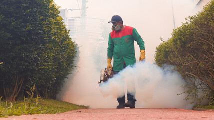 Um dedetizador executando uma nebulização no combate ao mosquito aedes aegypti