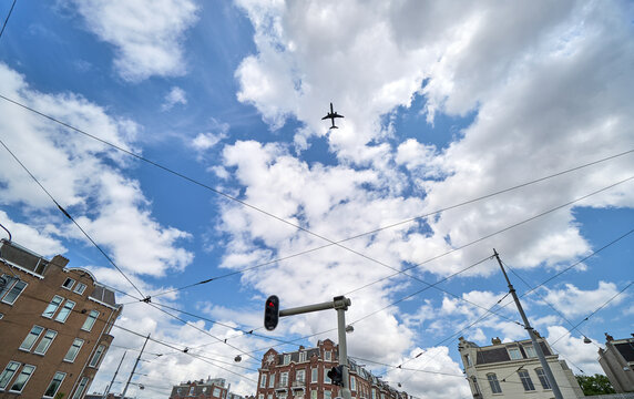 Jet airplane noise pollution overhead in an urban city street