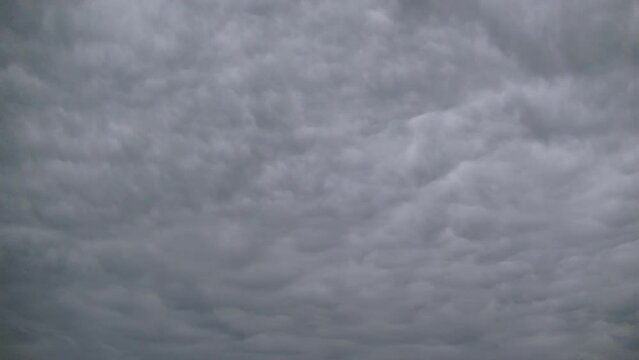 Natural structure of gray clouds moving in acceleration across sky - background, timelapse. Topics: texture, weather, meteorology, atmosphere, air, space