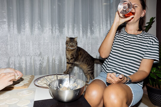 young woman and her cat cooking dumplings