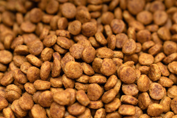 Food for animals background. Dry cat and dog food texture, pattern. Pet meal background close up. Dry food for pet dogs and cats. Dried pet food top view. Granules of good nutrition for dogs and cats.