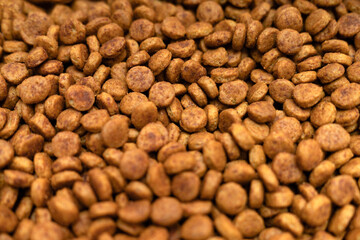 Food for animals background. Dry cat and dog food texture, pattern. Pet meal background close up. Dry food for pet dogs and cats. Dried pet food top view. Granules of good nutrition for dogs and cats.