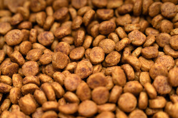 Food for animals background. Dry cat and dog food texture, pattern. Pet meal background close up. Dry food for pet dogs and cats. Dried pet food top view. Granules of good nutrition for dogs and cats.