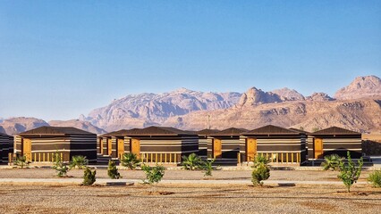 Row of houses on dirt with distant mountains in Wadi Rum, Jordan