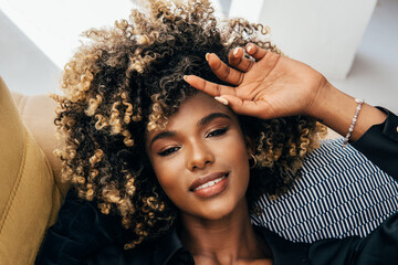 Serene afro woman with curly hair enjoying a peaceful moment
