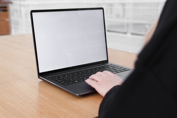 Young white woman working on computer with blank copy space screen on table in home office. close up female businesswoman hands typing text, surfing internet on modern laptop. mock up, front view