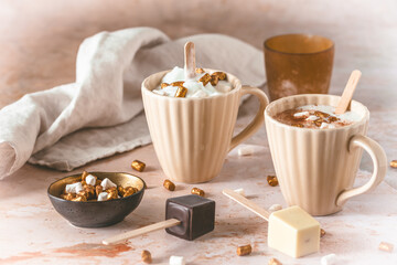 Two cups with hot chocolate dipping sticks and marshmallows