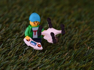 Fototapeta premium Tambov, Russian Federation - November 18, 2023 Lego boy minifigure with drone standing on a grass