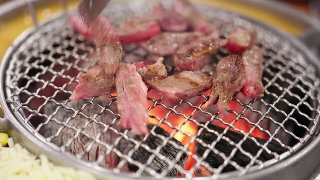 Let&rsquo;s eat Korean barbecue tonight. The charcoal is burning red. The fat beef rolls, beef and steak are grilled on the barbecue grill. The fat and oil are splashed out, and the aroma is delicious.