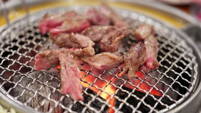 Let&rsquo;s eat Korean barbecue tonight. The charcoal is burning red. The fat beef rolls, beef and steak are grilled on the barbecue grill. The fat and oil are splashed out, and the aroma is delicious.