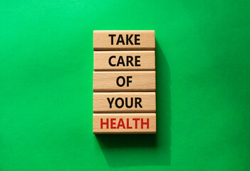 Health symbol. Wooden blocks with words Take Care of your Health. Beautiful green background. Health concept. Copy space.