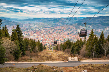 the beauty of Sarajevo's skyline from above. Journey through the cityscape in a cable car, passing over the rooftops - 783326158