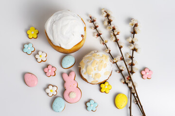 Easter cakes with Easter cookies and cherry blooming branches on white background