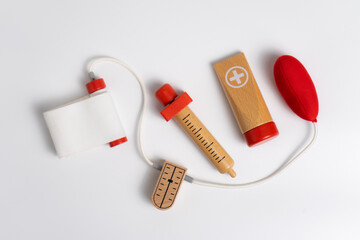 kids first aid kit wooden toys on white background, syringe, stethoscope, blood pressure monitor