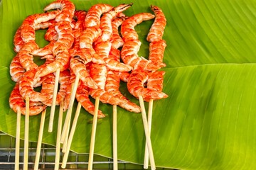 Grilled shrimp skewers on verdant banana leaf with taste of street food's simple yet rich flavors. Healthy, freshly cooked seafood at local market exudes both rustic charm and gourmet appeal