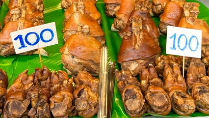 Asian street food. Exotic pork trotters, traditionally cooked and presented on banana leaves,...