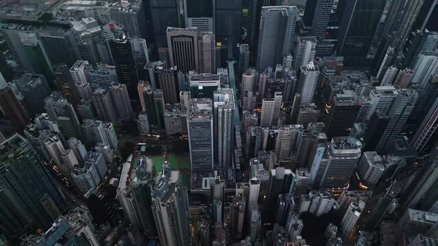 Modern skyscrapers and busy streets of Hong Kong filmed by drone from above. The grey concrete buildings give off a futuristic vibe illustrating the urban life of Asian metropolis. Town infrastructure