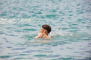A young man is swimming.