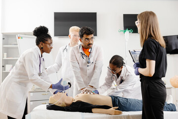 Group of people learning how to make first aid heart compressions with dummies during the training