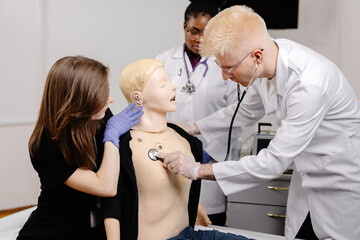 Fototapeta premium Female doctor examining male mannequin