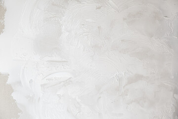 Applying decorative putty. White abstract texture of surface covered with putty