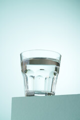 Glass of water on blue background. - 783348399