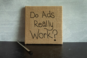 Square burlap canvas with the words Do Ads really work? handwritten on it 