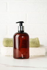 Soap bottle and towel stack on white bathroom background. - 783349993