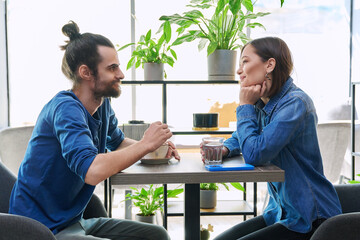 Laughing cheerful young couple sitting together in cafe